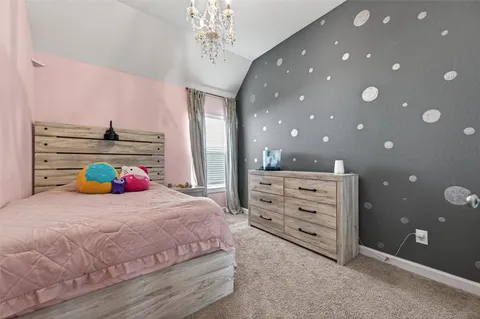 a bedroom with a bed and a chandelier