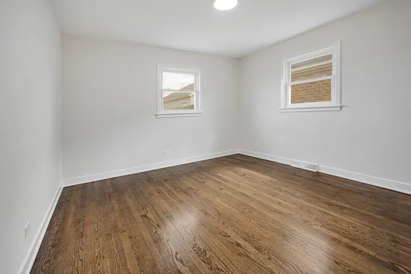 a view of a room with wooden floor and window