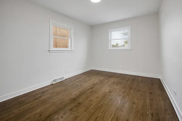 a view of a room with wooden floor and windows