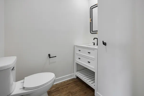 a bathroom with a toilet a sink and mirror