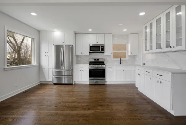 a kitchen with stainless steel appliances a refrigerator sink and microwave