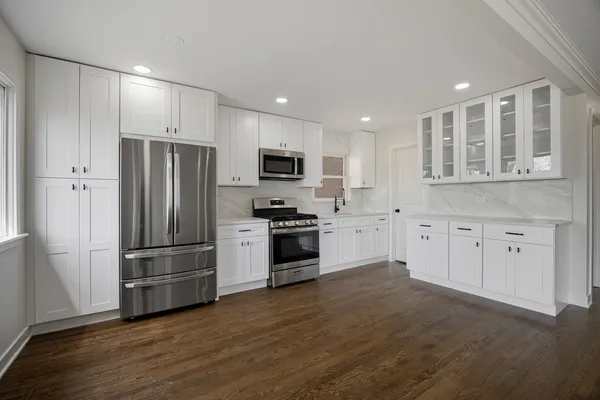 a kitchen with stainless steel appliances granite countertop a refrigerator and a stove top oven