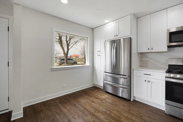 a kitchen with stainless steel appliances a refrigerator and a stove top oven