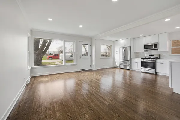 a view of a kitchen with wooden floor and electronic appliances