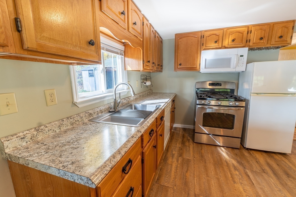 9 Chandler Road Holland, MA 01521 - Photo 9 of 42 a kitchen with stainless steel appliances granite countertop a sink a stove and a wooden floors