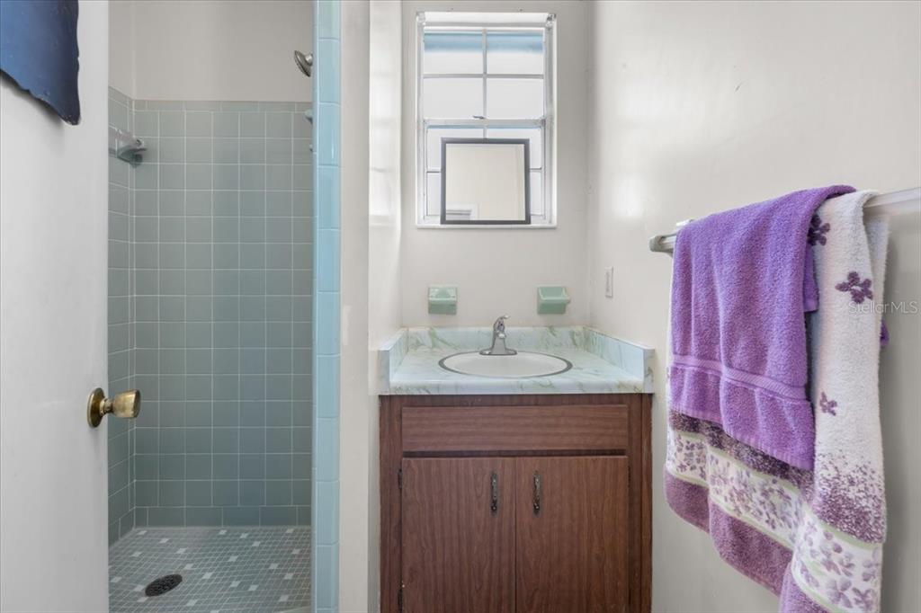 7422 County Road 231 Lake Butler, FL 32054 - Photo 35 of 57 a bathroom with a granite countertop sink a mirror a shower and vanity