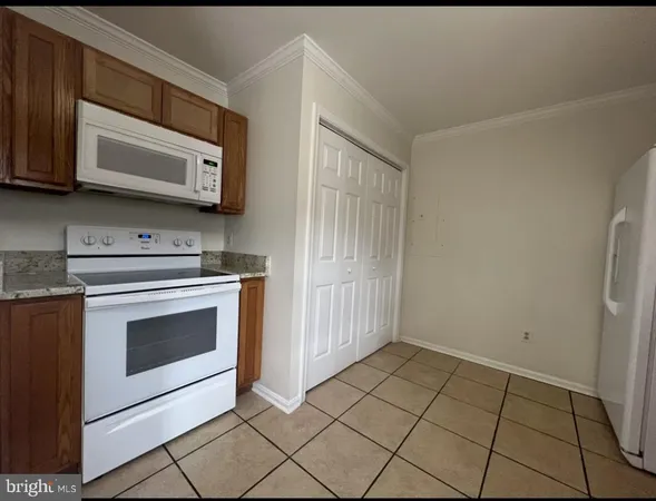a kitchen with granite countertop white cabinets stainless steel appliances and a sink