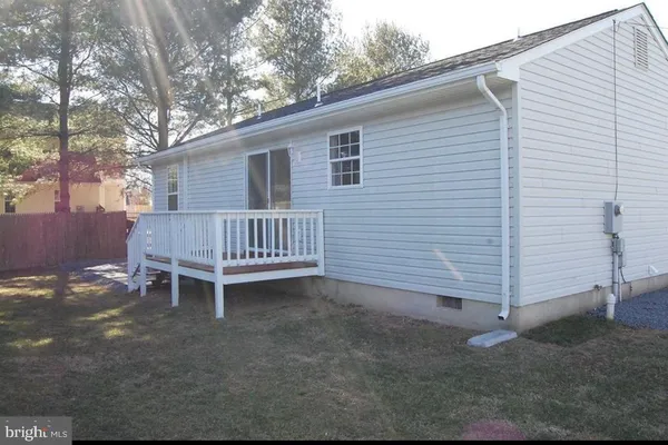 a backyard of a house with a bench and trees