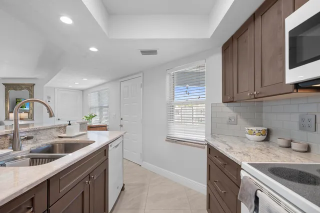 a kitchen with sink a microwave and cabinets