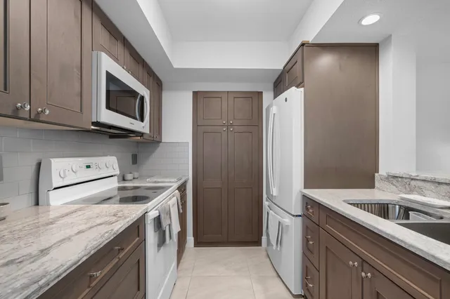 a kitchen with sink a microwave and cabinets