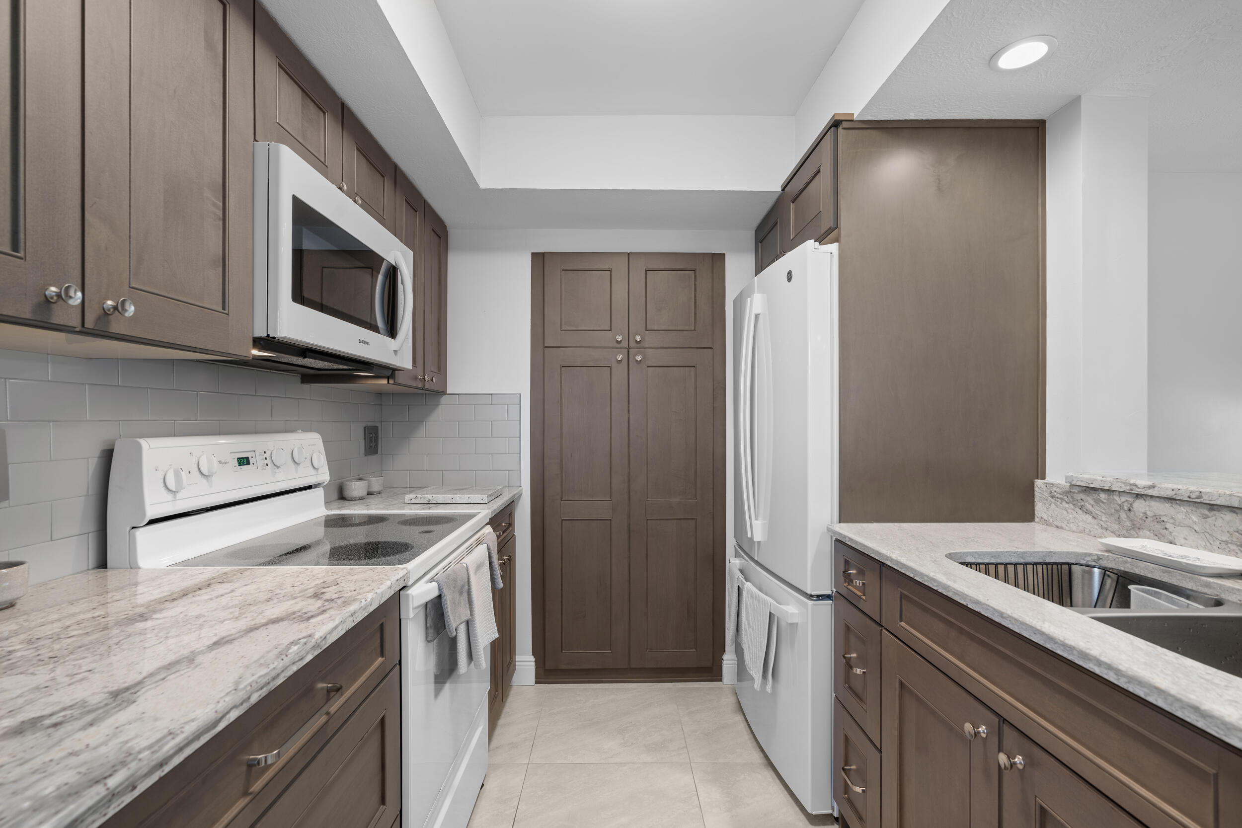 3236 Southeast Aster Lane, Unit M228 Stuart, FL 34994 - Photo 15 of 51 a kitchen with stainless steel appliances granite countertop a refrigerator stove and sink
