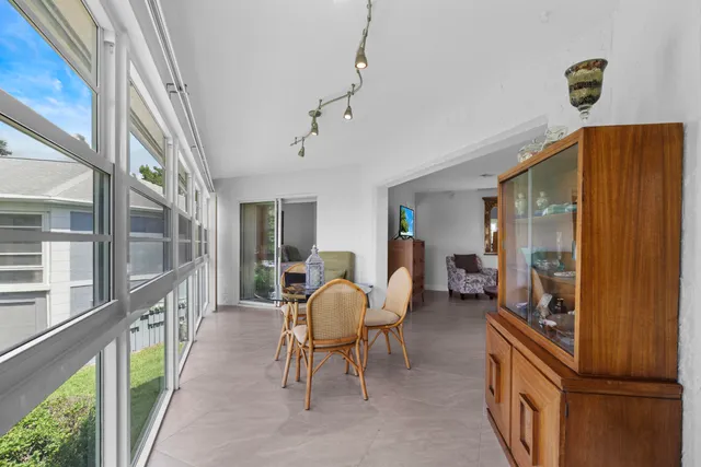 a dining room with furniture water view and a floor to ceiling window