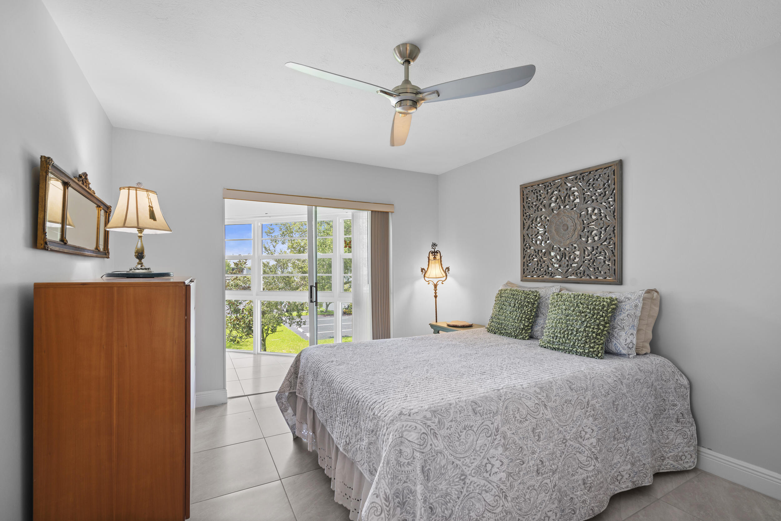 3236 Southeast Aster Lane, Unit M228 Stuart, FL 34994 - Photo 27 of 51 a bedroom with a large bed and a chandelier