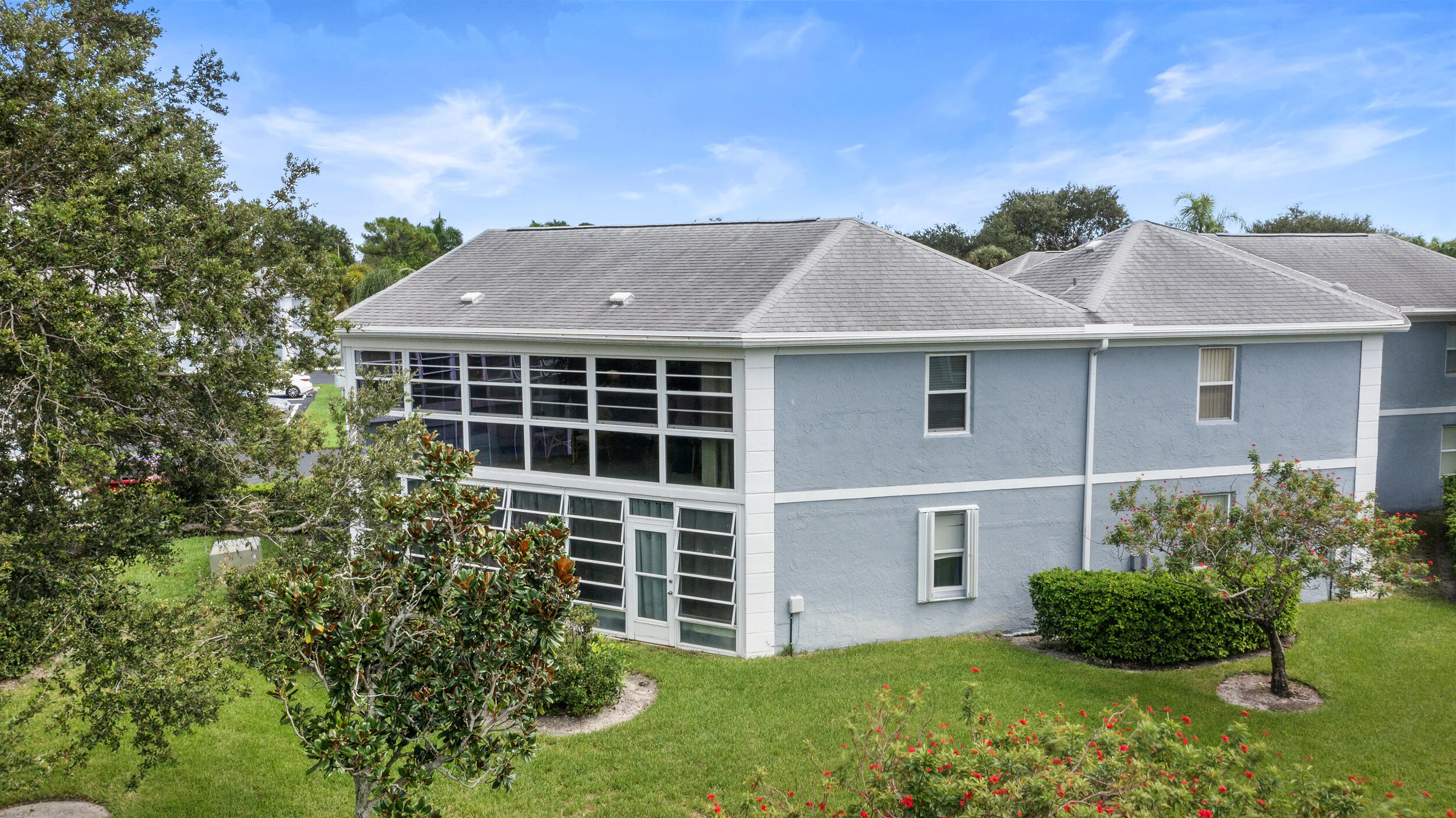 3236 Southeast Aster Lane, Unit M228 Stuart, FL 34994 - Photo 40 of 51 a front view of a house with a yard and garage