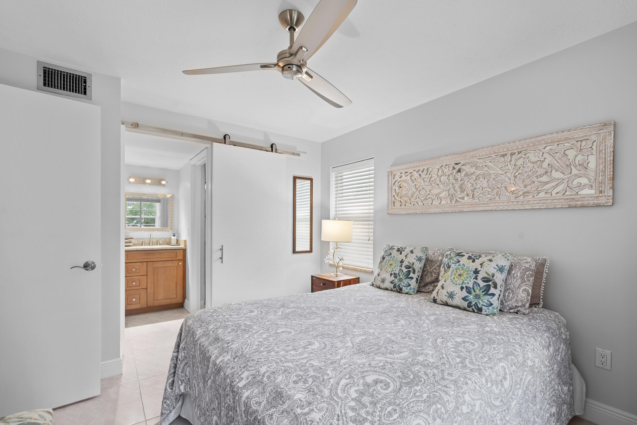 3236 Southeast Aster Lane, Unit M228 Stuart, FL 34994 - Photo 5 of 51 a bedroom with a bed and a painting on the wall