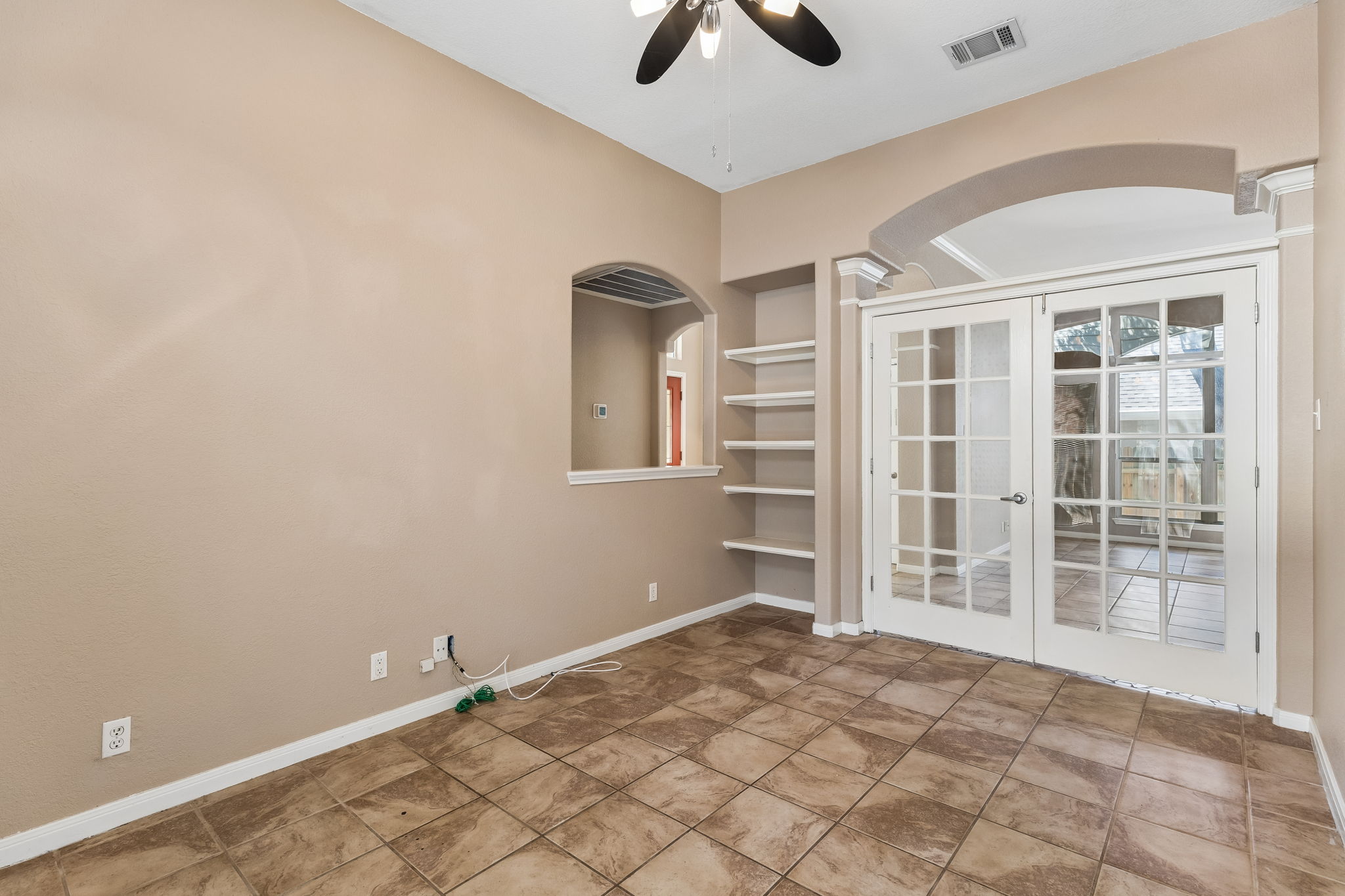 15814 Rustic Lane Austin, TX 78717 - Photo 11 of 29 Classic French doors and built-in shelving complement the durable tile flooring in this versatile space.