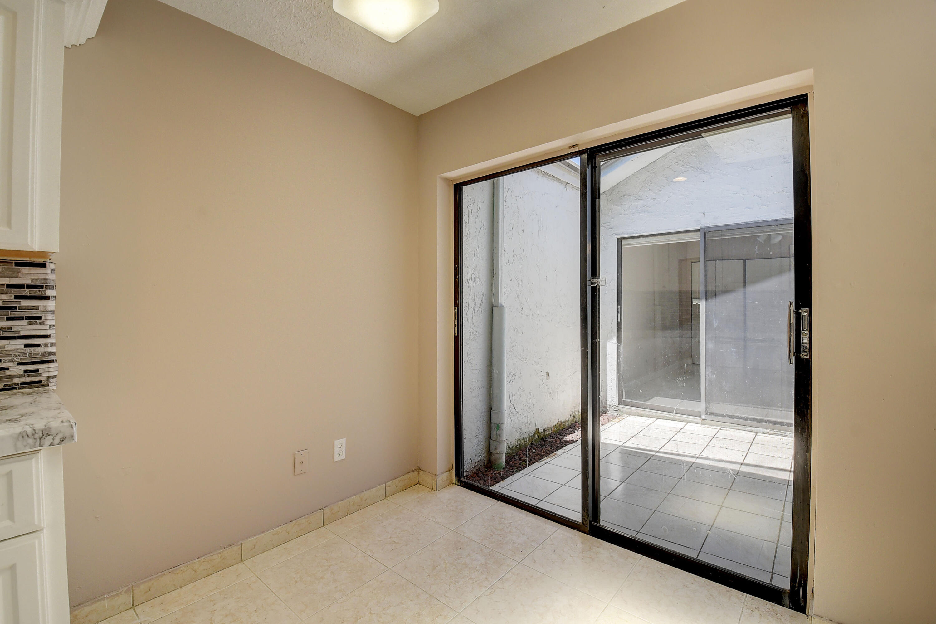 9105 Southwest 22nd Street, Unit E Boca Raton, FL 33428 - Photo 26 of 30 WALKOUT FROM KITCHEN TO PATIO