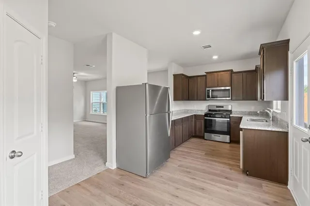 a kitchen with granite countertop stainless steel appliances and wooden cabinets