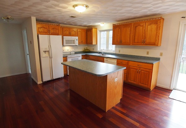 107 Nashua Road Pepperell, MA 01463 - Photo 3 of 22 a kitchen with stainless steel appliances granite countertop wooden cabinets a sink and a hard wood floor