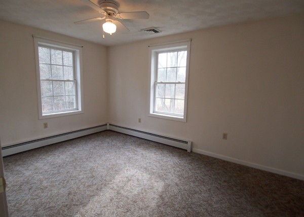 107 Nashua Road Pepperell, MA 01463 - Photo 9 of 22 an empty room with a window and ceiling fan