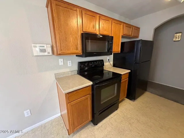 a kitchen with stainless steel appliances granite countertop a stove a refrigerator and a microwave oven