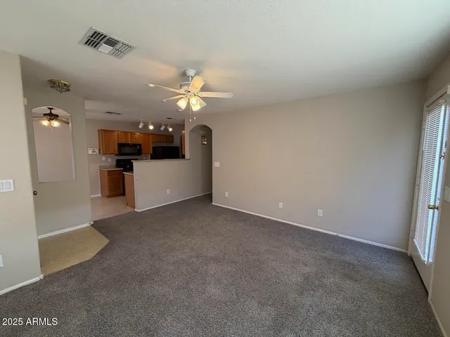 an empty room with a bathroom and a chandelier fan