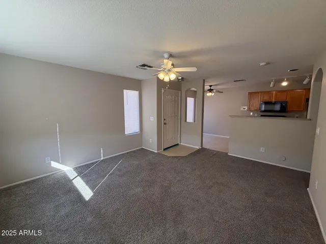 a view of a livingroom with a ceiling fan and window