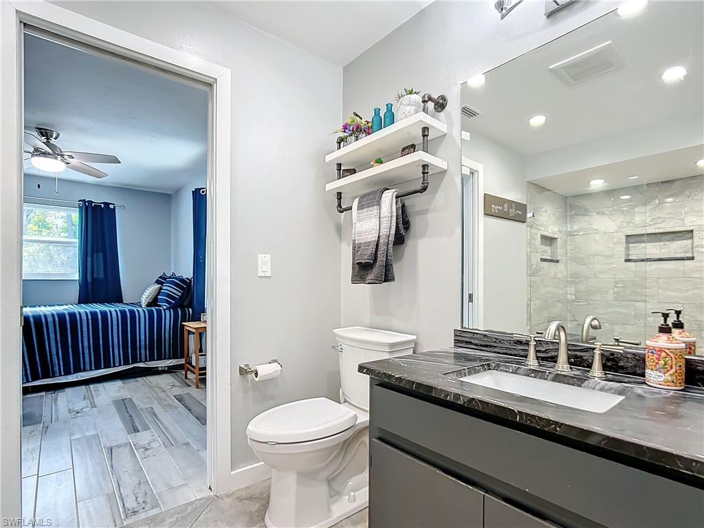 15711 Anderson Lane Fort Myers, FL 33912 - Photo 15 of 48 Downstairs bathroom featuring stone vanity, and a tile shower