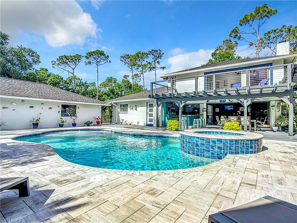 15711 Anderson Lane Fort Myers, FL 33912 - Photo 35 of 48 View of swimming pool featuring a pool with connected hot tub, a patio, a balcony, and a pergola
