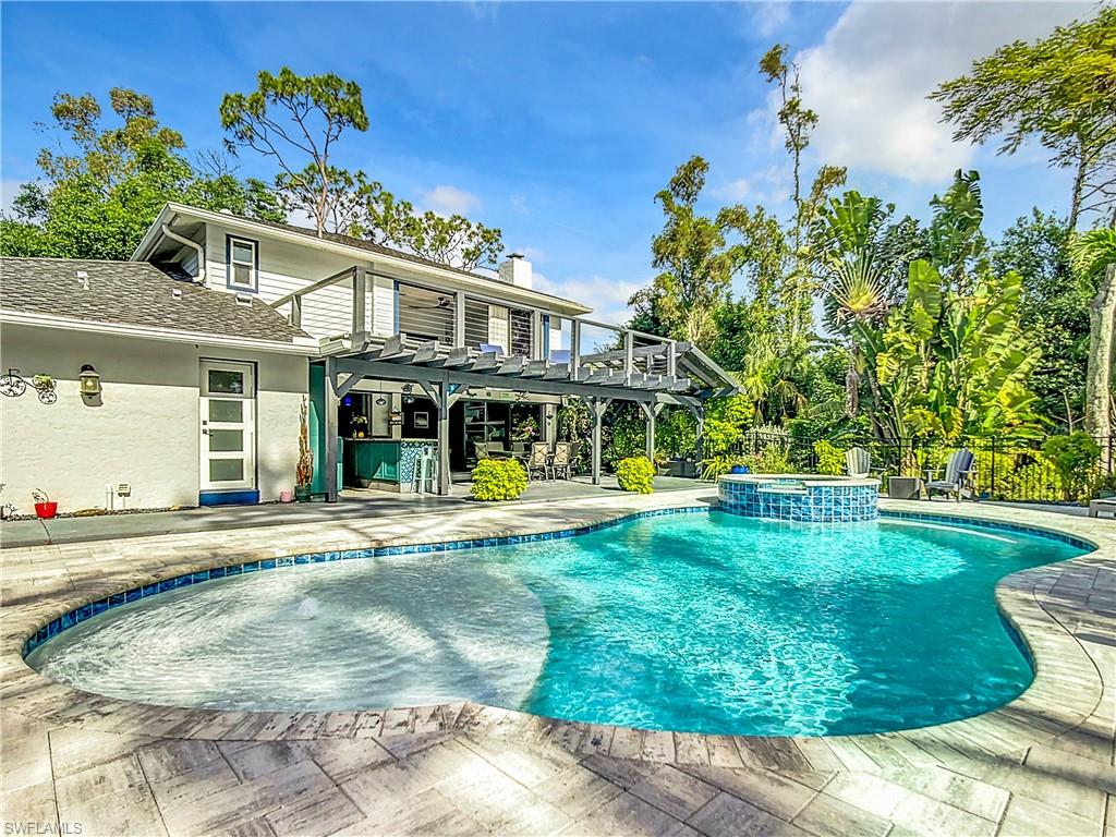 15711 Anderson Lane Fort Myers, FL 33912 - Photo 36 of 48 View of swimming pool featuring a pergola, a patio area, a pool with connected hot tub, and a balcony