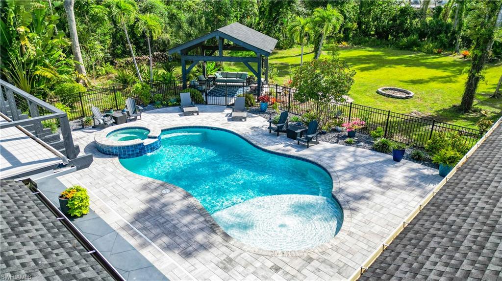 15711 Anderson Lane Fort Myers, FL 33912 - Photo 38 of 48 View of swimming pool with a fire pit, a patio, a pool with connected hot tub, and a fenced backyard