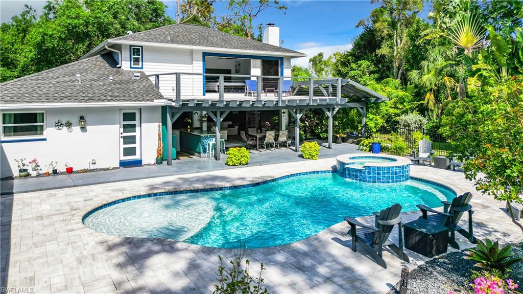 15711 Anderson Lane Fort Myers, FL 33912 - Photo 42 of 48 Back of house featuring a patio, a pool with connected hot tub, an alumium deck, and a covered outside entertainment area