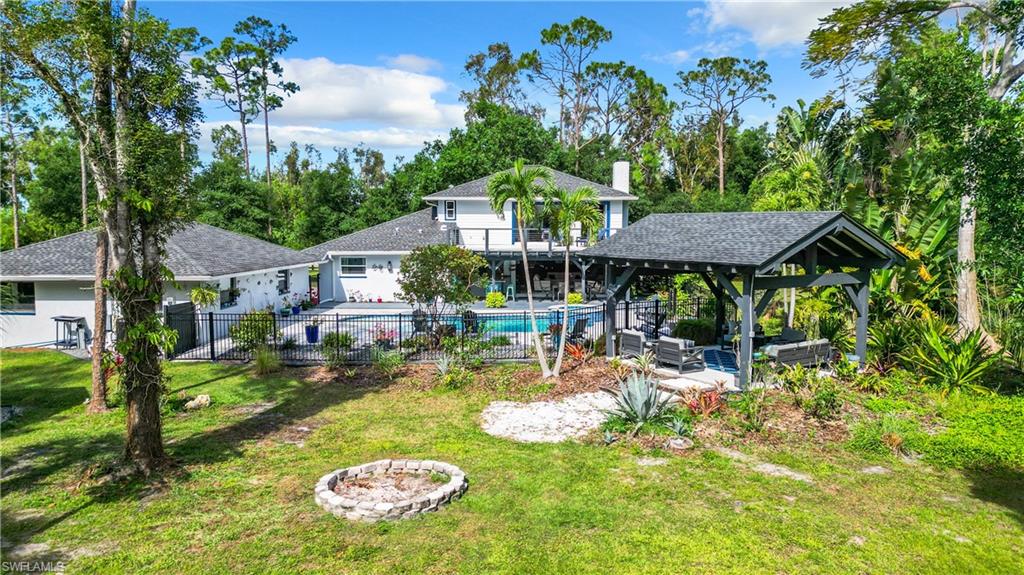15711 Anderson Lane Fort Myers, FL 33912 - Photo 44 of 48 Rear view of property with an outdoor living space with a fire pit, a patio area, a pavillion and a mancured landscape