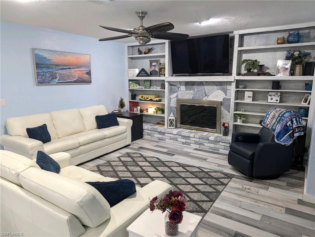 15711 Anderson Lane Fort Myers, FL 33912 - Photo 9 of 48 Living room with a wood burning ireplace, and a designer ceiling fan