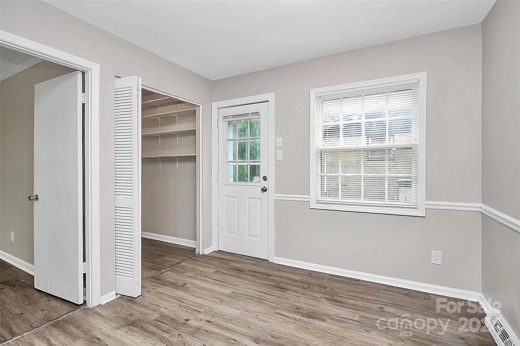 1120 Claremont Road Charlotte, NC 28214 - Photo 16 of 37 a view of an empty room with wooden floor and windows