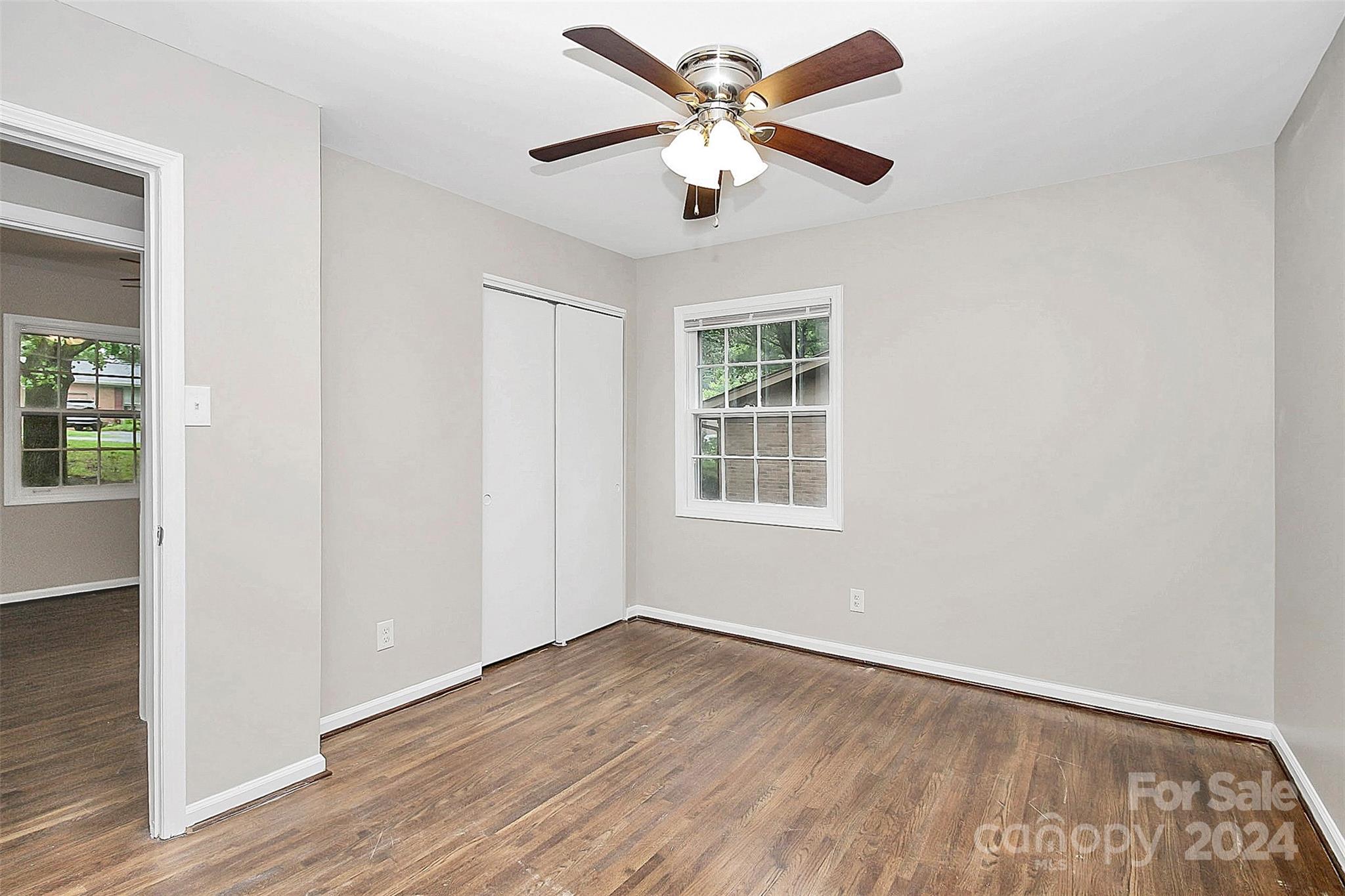 1120 Claremont Road Charlotte, NC 28214 - Photo 20 of 37 an empty room with wooden floor chandelier fan and windows