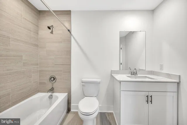 a bathroom with a granite countertop sink a toilet and shower