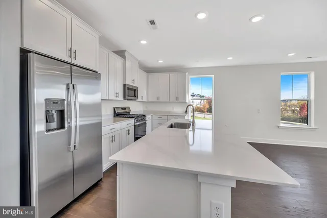 a kitchen with a refrigerator a sink and cabinets