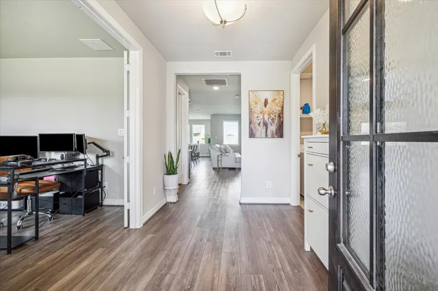 a view of a hallway with wooden floor and furniture