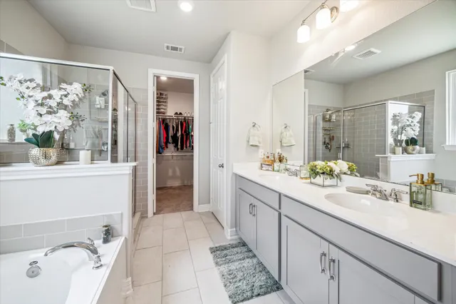 a spacious en suite bathroom with a granite countertop sink mirror and shower