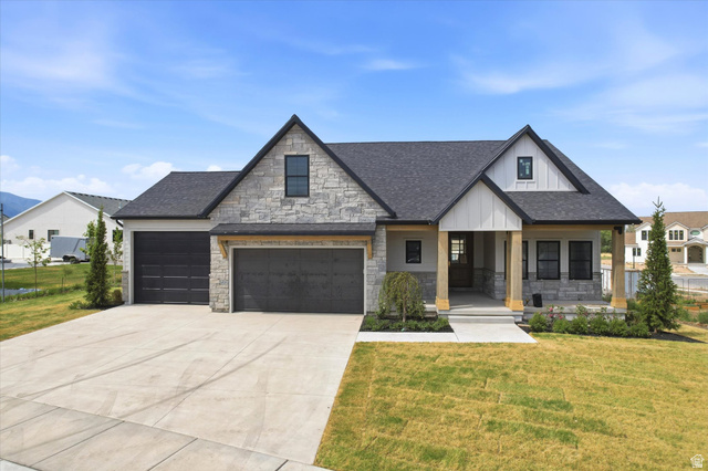 Stone and board-and-batten siding with a covered porch and substantial wood columns