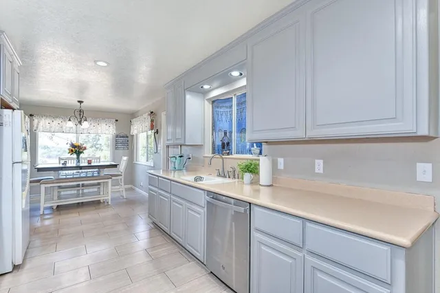 a kitchen with kitchen island granite countertop a sink and cabinets
