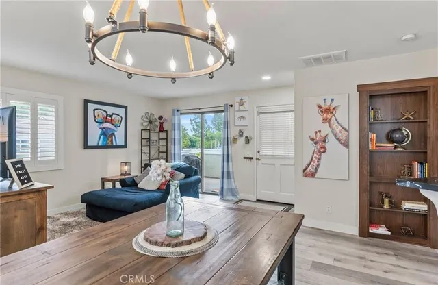 a view of a dining room with furniture a chandelier and wooden floor