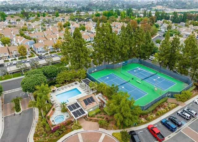 an aerial view of a pool yard and mountain view in back
