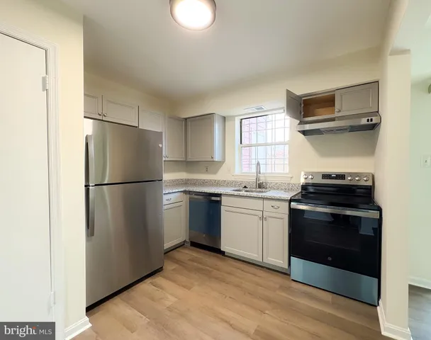 a kitchen with a refrigerator sink and wooden floor