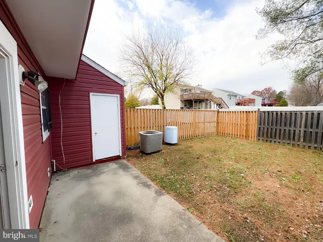 a view of a backyard with a fence and trees