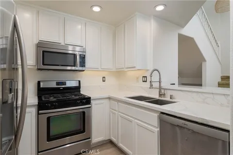 a kitchen with cabinets stainless steel appliances a sink and a microwave