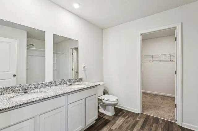 a bathroom with a granite countertop sink a toilet and a shower