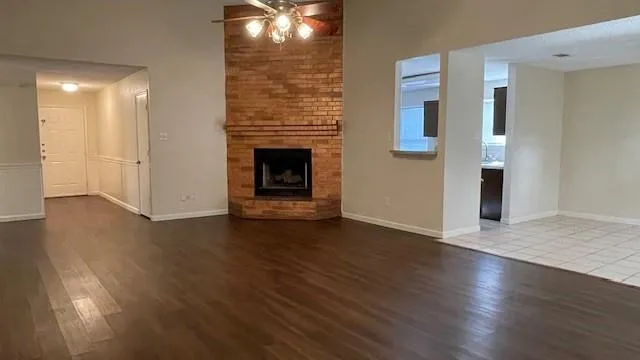 a view of a livingroom with wooden floor and a fireplace