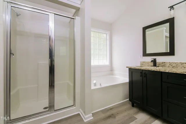 a bathroom with a double vanity sink mirror and shower